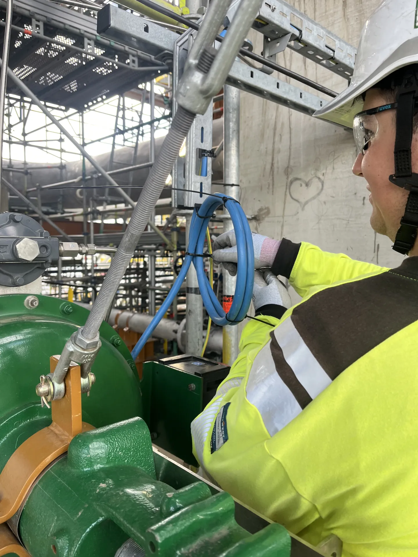 Elvium worker securing cables at industrial construction site